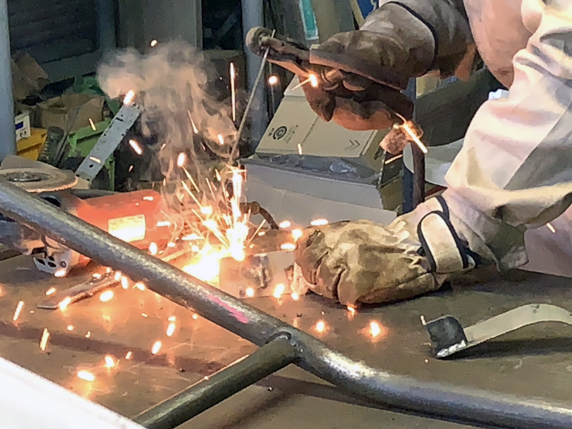 火花とヒュームが発生するアーク溶接作業